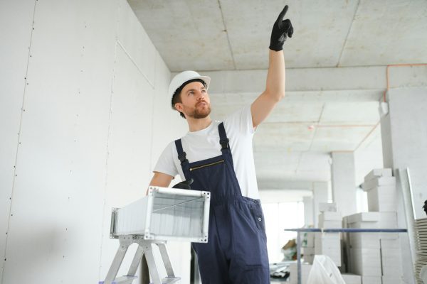 Warehouse Heating and Cooling System Installation by Professional Caucasian Technician.